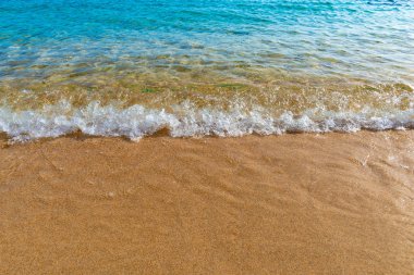 Mavi deniz suyu ile altın kum üzerinde küçük dalga, Korsika, Fransa 