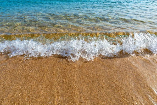 Kis hullám fröccsenő arany homok, kék tengervíz, Korzika — Stock Fotó