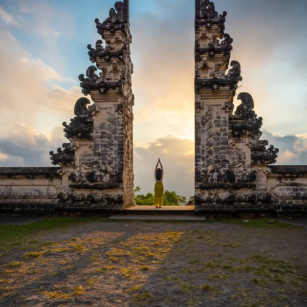 Tanınmayan bir kadın gün batımında Pura Luhur Lempuyang, Bali, Endonezya girişinde dua ediyor.