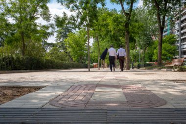 Madrid, İspanya - 25 Mayıs 2018: Şehrin merkezindeki gölgeli kaldırımda yürüyen iki işadamı