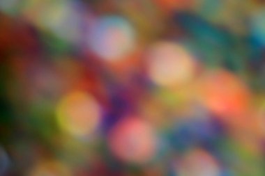 Arka planı koyu renkler olarak çeşitli renklerde bulanık renkli ışıklar