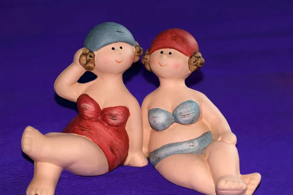 Dwie Figurki Przytulnych Pań Garniturach Kąpielowych Rozmiarem Xxl Niebieskim Tle — Zdjęcie stockowe