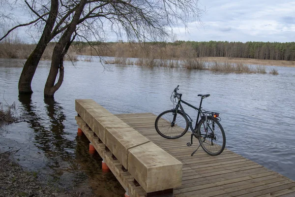 Black bike on a wooden bridge near the river
