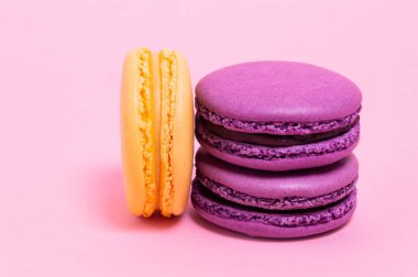 Pembe bir arka plan üzerinde üç renkli macaroons.