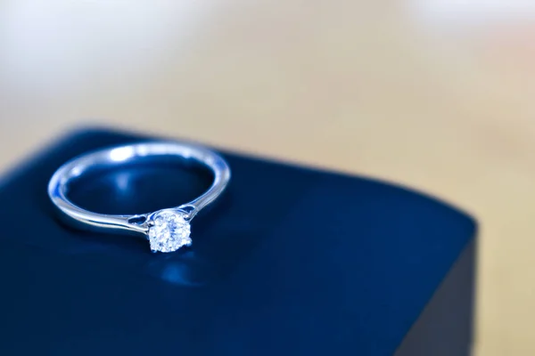 Diamantový zásnubní prsten na poli modrý kroužek — Stock fotografie