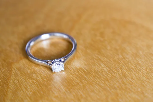 Diamond bílé zlato zásnubní prsten na dřevěný stůl — Stock fotografie