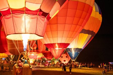 CHIANGRAI, THAILAND - 15 Şubat 2019 Singha Park Chiang Rai Uluslararası Balon Festivali 'nde 13-17 Şubat 2019 tarihleri arasında havai fişek gösterisi sonrası karanlık gökyüzünde canlı sıcak hava balonları