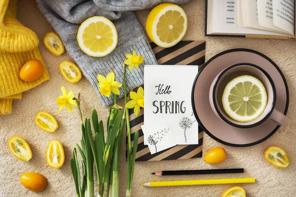 yellow daffodils flowers and tea on background