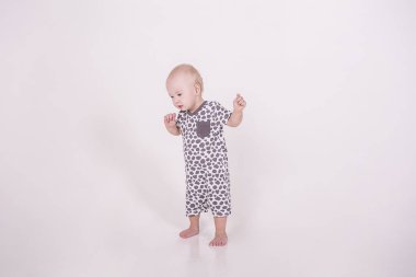 küçük bir bebek beyaz bir arka plan üzerinde yürüyor