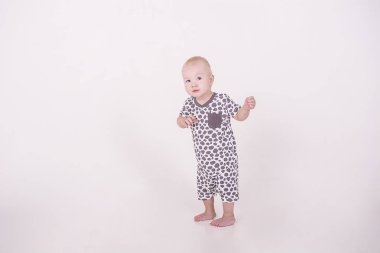 küçük bir bebek beyaz bir arka plan üzerinde yürüyor