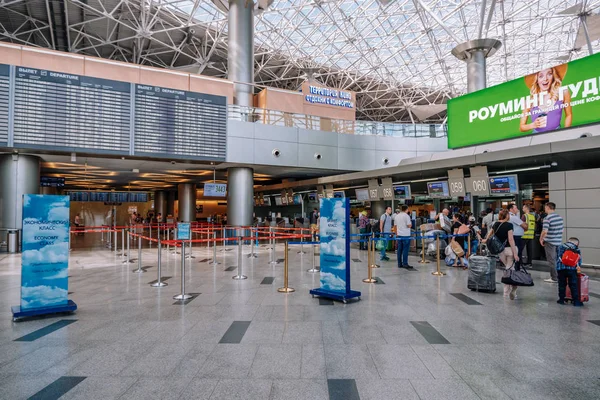 Moskova / Rusya - 18 Haziran 2019: Vnukovo Havaalanı'nda uçuş kartı ile yolcu check-in alanı. Yolcular arka planda uçuşlar için check-in.