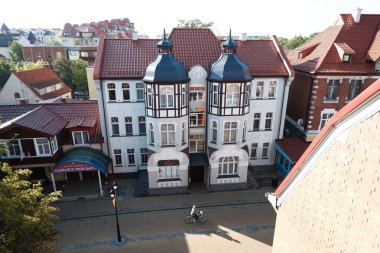 Zelenogradsk / Rusya - 23 Ağustos 2019: Zelenogradsk evlerinin pencereden görünümü. Kurortny Prospect sokakta bisikletçi sürmek