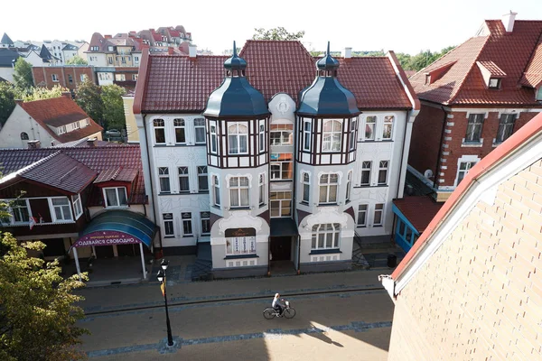 Zelenogradsk / Rusya - 23 Ağustos 2019: Zelenogradsk evlerinin pencereden görünümü. Kurortny Prospect sokakta bisikletçi sürmek