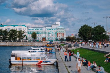Yekaterinburg / Rusya - 10 Ağustos 2019: İnsanlar Yekaterinburg'un merkezindeki Iset nehri üzerinde yürüyor. Arka planda Dom N.i. Sevastyanova, Lenina sokak ve Antey kulesi