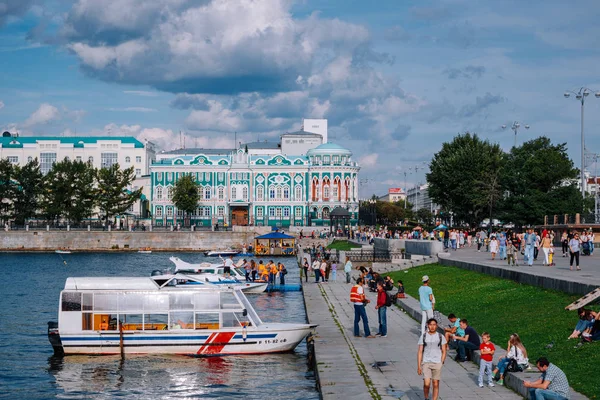Yekaterinburg / Rusya - 10 Ağustos 2019: İnsanlar Yekaterinburg'un merkezindeki Iset nehri üzerinde yürüyor. Arka planda Dom N.i. Sevastyanova, Lenina sokak ve Antey kulesi