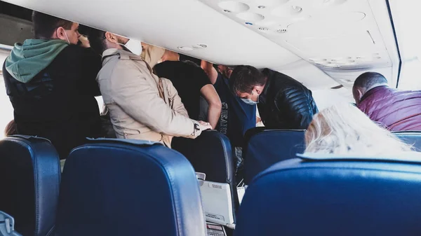 莫斯科 俄罗斯 2020年9月18日 戴反海盗面具的乘客从飞机上的座位上站起来 迅速走向出口 图库图片