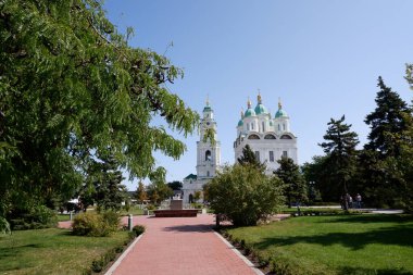 Astrakhan / Rusya - 18 Eylül 2020: Astrakhan. Astrakhan Kremlin. Varsayım Katedrali ve Astrakhan Kremlin 'in çan kulesi. Katedralin önündeki yeşil çimenler ve ağaçlar.