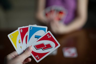 Chelybinsk, Rusya - 25 Aralık 2018: Amerikan kart oynarken oyun Uno oyun holding, kadın elinde kartları. 