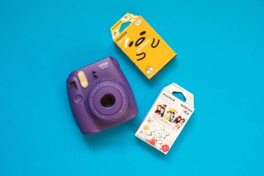Fujifilm Instax mini kamera ve gudetama ve mavi arka plan üzerinde Winnie the Pooh anlık film