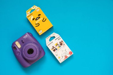Fujifilm Instax mini kamera ve gudetama ve mavi arka plan üzerinde Winnie the Pooh anlık film