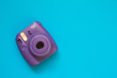 Fujifilm instax mini camera  instant film on blue background clipart