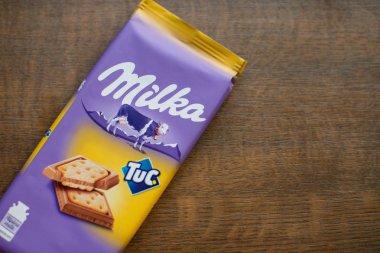 Milka çikolata bar Tuc kırık tahta arka plan ile. Milka Mondelz International (Kraft Foods tarafından çikolata şekerleme markasıdır.)