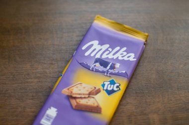 Milka çikolata bar Tuc kırık tahta arka plan ile. Milka Mondelz International (Kraft Foods tarafından çikolata şekerleme markasıdır.)