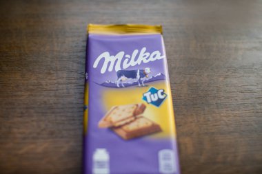 Milka çikolata bar Tuc kırık tahta arka plan ile. Milka Mondelz International (Kraft Foods tarafından çikolata şekerleme markasıdır.)