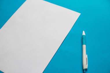 Beyaz kağıt listesi ve kalem mavi zemin üzerine