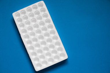 Strafor kontakt lensler şişe veya mavi arka plan üzerinde test tüpleri gibi başka bir küçük kırılabilir eşyalar için