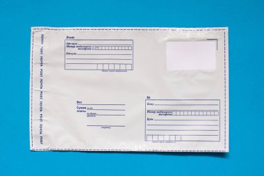 Rus yazı polietilen zarf üzerinde mavi arka plan. Plastik posta e-posta çanta