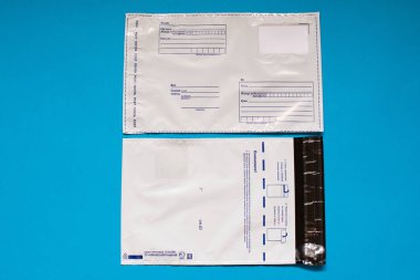 Rus yazı polietilen zarf üzerinde mavi arka plan. Plastik posta e-posta çanta