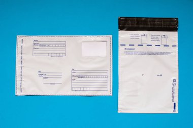 Rus yazı polietilen zarf üzerinde mavi arka plan. Plastik posta e-posta çanta