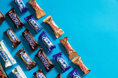 Twix, Samanyolu, Snickers, ödül, Mars popüler mini şeker çikolata üzerinde mavi arka plan ile alanı Kopyala