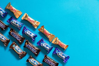 Twix, Samanyolu, Snickers, popüler mini çikolata şekerleme kopya alanı ile mavi arka plan üzerinde