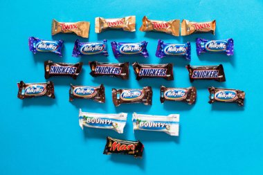 Twix, Samanyolu, Snickers, ödül, Mars popüler mini şeker çikolata üzerinde mavi arka plan ile alanı Kopyala