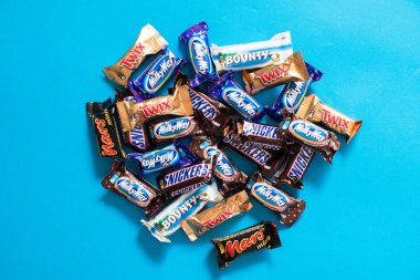 Twix, Samanyolu, Snickers, ödül, Mars popüler mini şeker çikolata üzerinde mavi arka plan ile alanı Kopyala