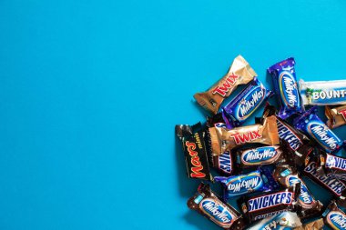 Twix, Samanyolu, Snickers, ödül, Mars popüler mini şeker çikolata üzerinde mavi arka plan ile alanı Kopyala