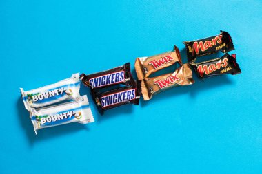 Twix, popüler mini çikolata şekerleme üzerinde mavi arka plan ile Snickers, ödül, Mars uzay kopyalayın.