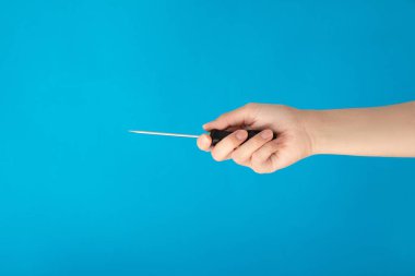 Mavi arka plan üzerinde tornavida tutan el. Onarmak ve saptamak vida kavramı