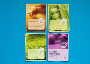 Tony Moly levha maskeleri düz mavi arka plan üzerinde yatıyordu. Kore Kozmetik üst görünümü.