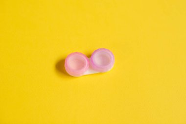 Sarı arka planda pembe kontakt lens kılıfları