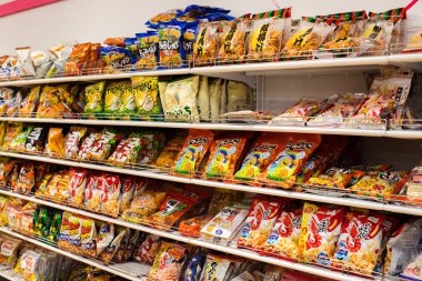 Daiso 100 yen dükkanın iç, Osaka patates cipsi gibi ucuz Japon aperatifler ile raflar, Japonya