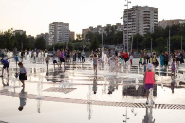 Mutlu çocuklar oynamak ve şehir merkezinde sokak çeşmesinde eğlenin