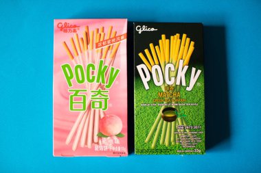 Yeşil çay matcha ve japon beyaz şeftali momo lezzet ile Pocky Bisküvi Sticks. Pocky, Ezaki Glico tarafından üretilen bir atıştırmalık gıdadır.