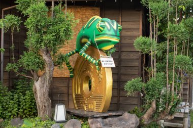 Kawagoe, Japonya: Büyük yeşil bukalemun ve 5 jpy bozuk para heykeli - para konsepti