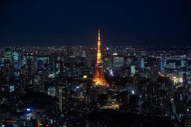 Tokyo Kulesi 'nin arka planı, Tokyo' nun geceleri gökdelenler arasında olması.