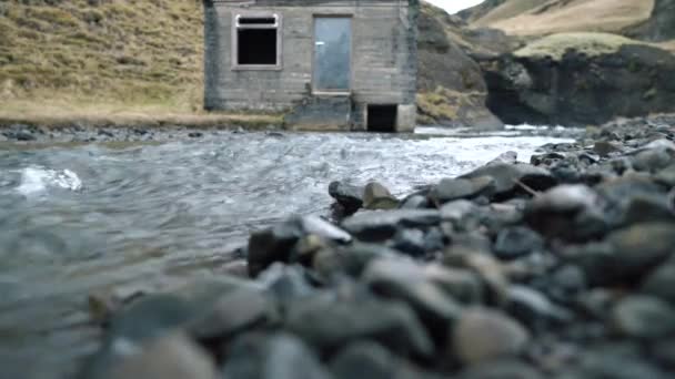 Niski poziom widoku chaty przez strumień — Wideo stockowe