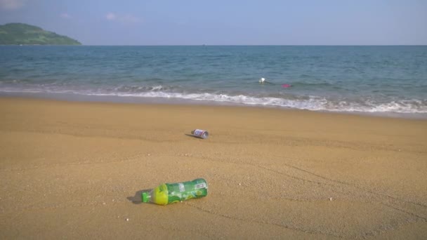 Botellas de plástico en una playa de arena — Vídeo de stock