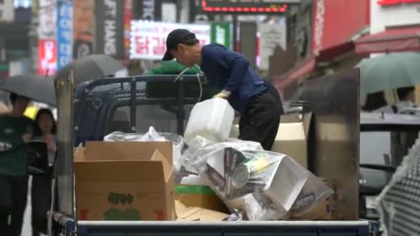 Disparo de un hombre arreglando cajas en la parte trasera de un camión en Seúl — Vídeo de stock